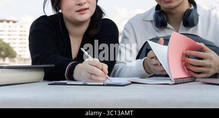 Group of Students Engaged in Online Learning Outdoors with Laptops and Notebooks in a Collaborative Study Session Stock Photo