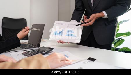 Business Team Collaborates on Data Analysis with Graphs in Modern Office Setting Stock Photo