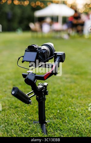Professional DSLR mounted on gimbal stabilizer for video recording. Close-up of a mirrorless camera mounted on a handheld gimbal stabilizer tripod. Stock Photo