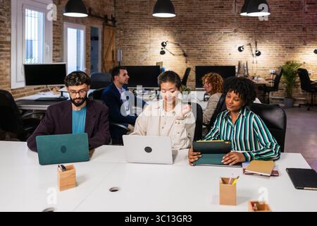 Multi ethnic team collaborating on project in modern office Stock Photo