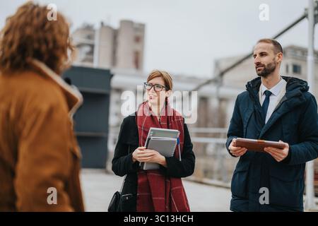 Professional discussion outdoors between business associates exchanging ideas and documents Stock Photo
