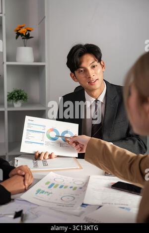 Business Team Collaborates on Data Analysis with Graphs and Charts in Modern Office Setting Stock Photo