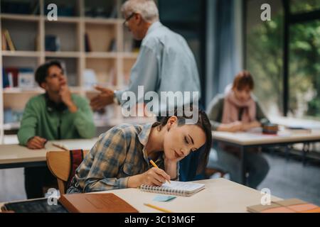 Students engaging with elderly professor in active classroom setting Stock Photo