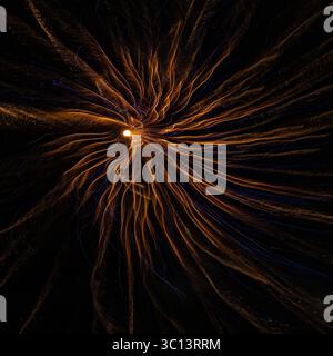 Against the black background the abstract close up of firework looks like an other-worldly explosion. The image is full of energy and bright colours. Stock Photo
