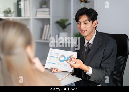 Professional Business Team Collaborating on Project Strategy and Analyzing Work Plans in Modern Office Setting Stock Photo
