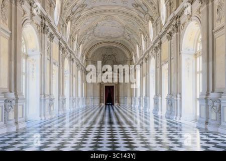 Venaria, Italy - 25 June 2021: View of the Galleria Grande, a hall of shimmering marble and light, reflecting off the black and white checkered floor. Stock Photo