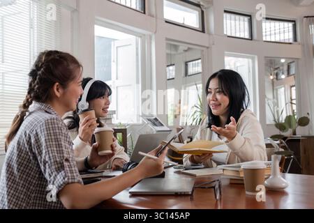 Diverse Group of Students Collaborating on Homework in a Modern Study Space with Laptops and Books Stock Photo
