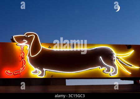 Albuquerque, New Mexico, USA — Neon sign of a dachshund at the Dog House hot dog stand on Route 66, lit at night with a wagging tail and a string of h Stock Photo