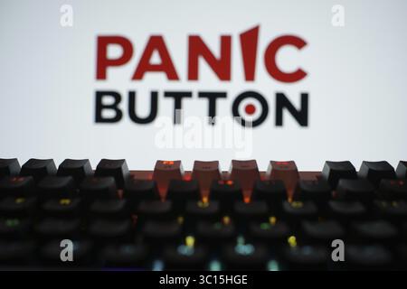 A brightly lit keyboard in front of a screen displaying the Panic Button logo Stock Photo