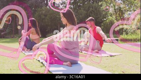 Practicing three friends sitting cross-legged on yoga mats in backyard garden, with heart graphics Stock Photo