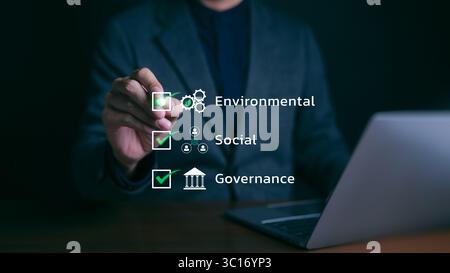 ESG environmental social governance strategy investment business concept. Businessman checking mark on checklist with checkmark on virtual screen. Stock Photo