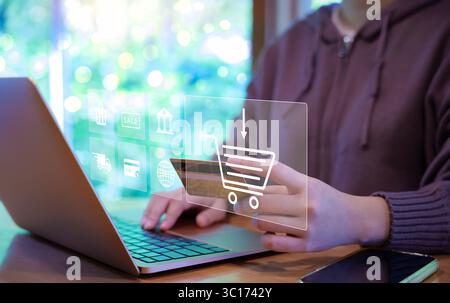 Woman use laptop to shop online with shopping cart and business icons. Purchase order, Digital marketing concept, Retail market on the Internet websit Stock Photo