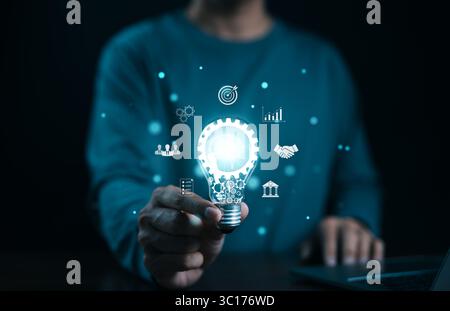 Idea solution business strategy concept. Businessman hand holding light bulb with business icons. Digital marketing, Financial and banking, Internet Stock Photo