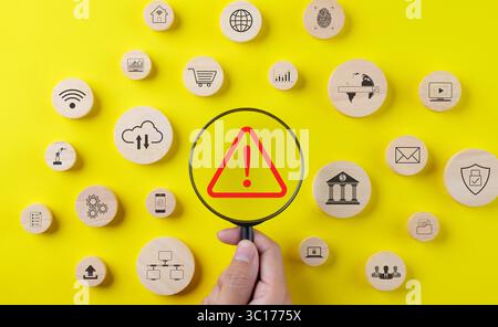 Error notification concept. Magnifying glass focusing red triangle caution warning sign and wood block with business technology icons Stock Photo
