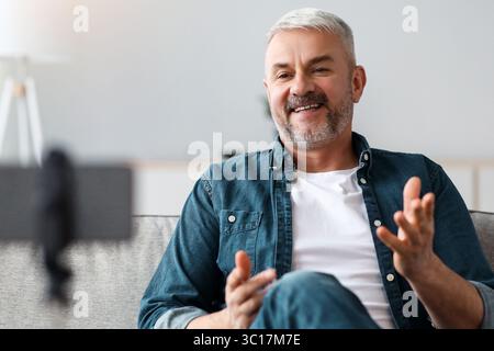 Happy handsome senior man broadcasting from home Stock Photo