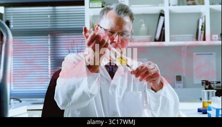 Dispensing senior scientist wearing lab coat in lab, holding pipette and filling beaker with liquid Stock Photo