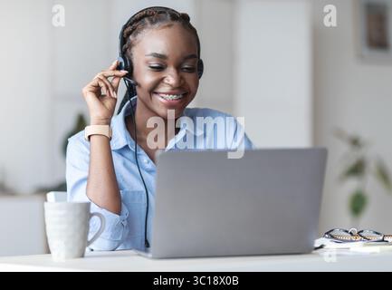 Customer Support. Black woman manager wearing headset and using laptop in office Stock Photo