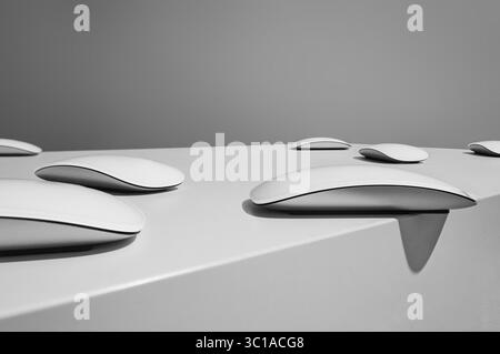 A minimalist photograph showcases a row of PC Mouse devices resting on a smooth, reflective surface. The mice are positioned closely together, creatin Stock Photo