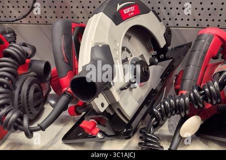 Babruisk, Belarus - June 11, 2025: An electric circular saw rests on a tool bench surrounded by other workshop tools. Stock Photo