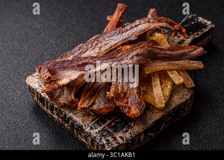 Dried salted fish as snacks or jerky, seafood as slices. Dried seafood snacks as a background for your design Stock Photo
