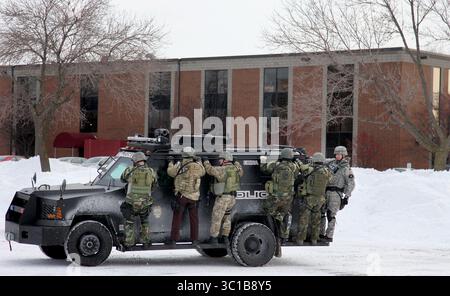 December 10, 2009 - Minneapolis, MN - Armored members of a SWAT team left the office building where a stand-off took place this afternoon in Roseville. At least two women were seen running to safety with the officers from the building just before 2 p.m. Authorities closed down the neighborhood around the complex near the intersections of County Road B and Fairfiew. (Credit Image: Elizabeth Flores/Minneapolis Star Tribune/TNS via ZUMA Wire) Stock Photo