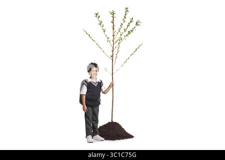 Boy in a school uniform holding a tree isolated on white background Stock Photo