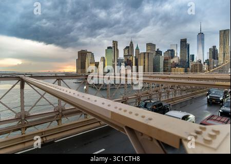 Traffic on Brooklyn Bridge with storm clouds over Manhattan Financial District, New York, USA Stock Photo