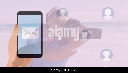 Connecting smartphone with envelope icon to couple using phone on beach via profiles, copy space Stock Photo