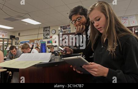 Jan. 31, 2012 - Lakeville, MN - Minnesota, U.S. - (left to right) Lakeville South High School Students Josephine Sanchez and Haylee Unruh used an Ipad to access a virtual textbook during Jason Just's AP chemistry class at the school on 1/31/12. The students were using netbooks, smart phones, laptops and tablets to access the class materials. Lakeville is looking to become one of the most high tech districts in the state. It will start by making all of its schools wireless by April and include giving handheld devices or laptops to every kid and teacher in grades 3-12. Among the pioneers is chem Stock Photo