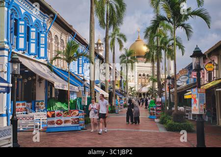 View of colorful Muscat St., lined with traditional shophouses, and Sultan Mosque in Kampong Glam, Singapore; with Asian and Western tourists visiting Stock Photo