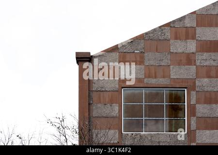 Minimalist architectural detail of a modern building facade with a checkerboard pattern and a window. Abstract background with copy space. Stock Photo