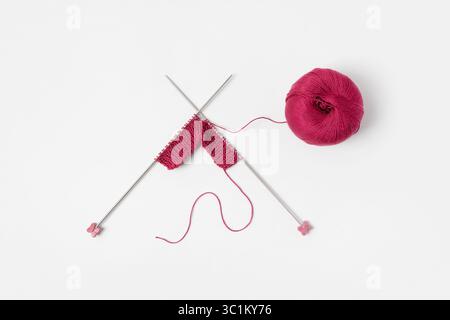 Vinous knitted wool on gray background with knitting needles for knitting warm clothes and hobbies needlework Stock Photo