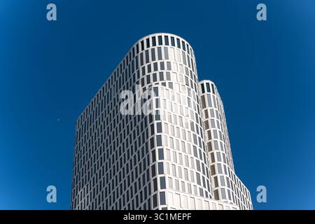 Zoofenster Building. The iconic white facade of the Upper West Berlin building gleams in sunlight, set against a vivid blue sky. Its modern, rounded d Stock Photo
