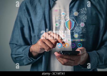 Digital security shield protecting a phone represents cybersecurity, data protection with encrypted online systems, along with cyber stats as mobile c Stock Photo
