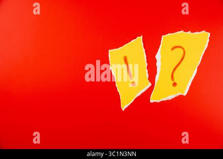 Yellow paper torn with exclamation mark and question mark ?!? on vibrant red background for attention-grabbing visuals in marketing and communication Stock Photo