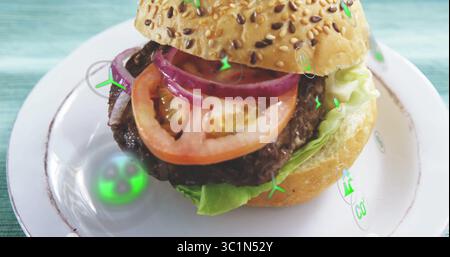 Presenting seeded burger with beef patty, tomato slices and onion rings on plate on turquoise table Stock Photo