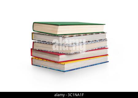 A front side on view of a pile of five study books, textbooks, on a table isolated against a white background Stock Photo