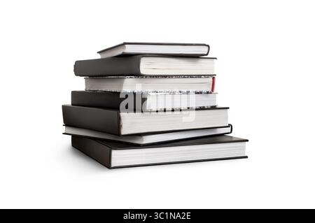 A front side on view of a pile of seven study books, textbooks, on a table isolated against a white background Stock Photo