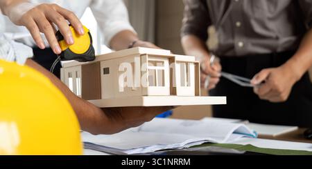 Eco-Friendly Building Design. Team collaborating on sustainable architecture model. Stock Photo