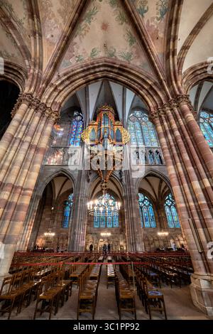 Strasbourg Cathedral de Notre-Dame interior in Strasbourg, France. View from south to north collateral aisle of the nave with Grand Organ and stained Stock Photo