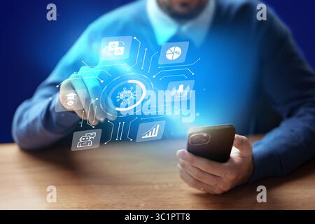 Man using smartphone with holographic technology display in modern workspace at night Stock Photo