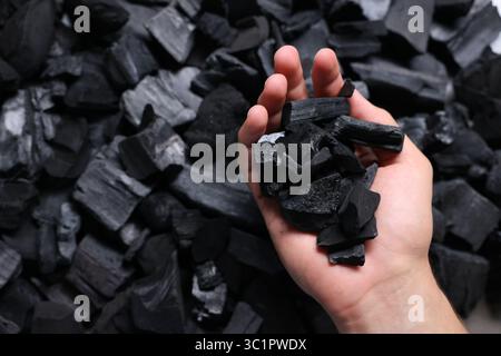 Man with black coals over pile, above view Stock Photo
