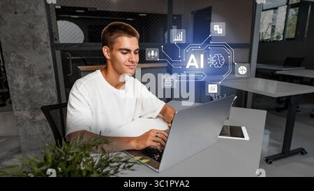 Engaged young man working on laptop in modern office with AI technology representation Stock Photo