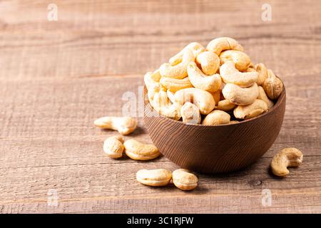 Organic roasted cashew nuts in a wooden bowl. Top view. Stock Photo