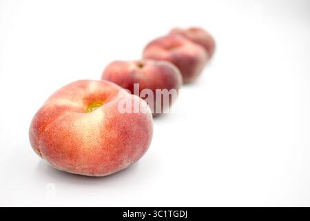 Flat peaches isolated against white background Stock Photo