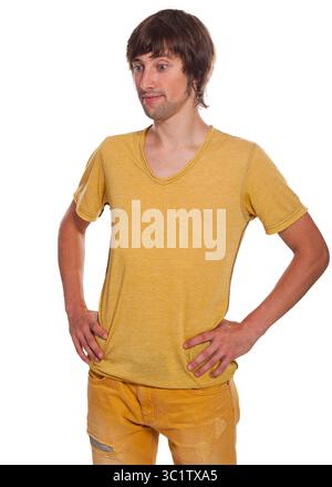 A man stands with hands on hips, showcasing a bright yellow shirt and jeans. Stock Photo
