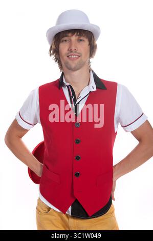Man showcases his unique style in a vibrant red vest and white hat indoors. Stock Photo