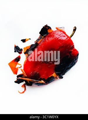 Grilled red bell pepper almost peeled isolated on a white background. Vegetarian and healthy food. Directly above. Stock Photo
