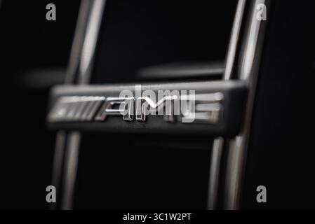 Close Up of Metallic AMG Badge on Sleek Black Surface Stock Photo