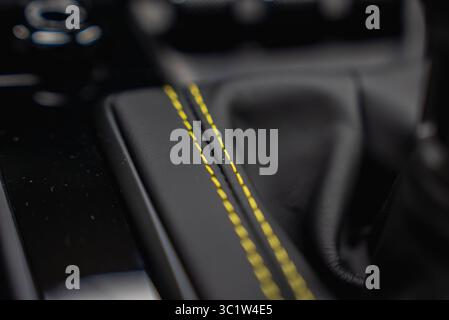 Close Up of Black Leather with Yellow Stitching in Luxury Car Interior Stock Photo